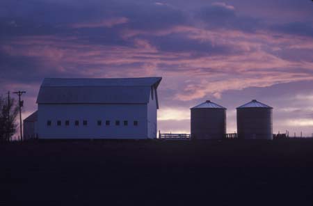barn and silos at sunset